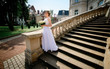 © IVASHstudio - young and beautiful bride in white dress standing on the stairs