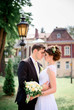 © IVASHstudio - young and beautiful bride and groom standing near manor