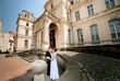 © IVASHstudio - young and beautiful bride and groom standing near manor