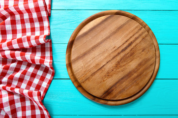 Wall Mural - Frame of round cutting board and red plaid tablecloth. Blue wooden background 