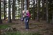 © Petr Bonek - Young child boy (brother) giving his sister piggyback outdoors in the forest. Children summer activities.