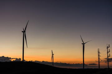 Silhouette wind generators turbines on sunset summer landscape i