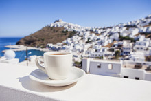 Traditional Greek Coffee On A Balcony With Beautiful Greek Mediterranean Town On The Background. Vacations In Greece