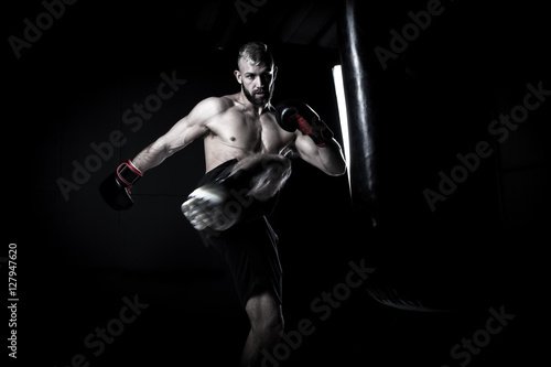 Dekoracja na wymiar  bokser-meski-sportowiec-uderzajacy-w-worek-treningowy-z-dramatycznym-ostrym-li