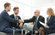 © ASDF - Handshake between businesspeople in a stylish office  in the bac