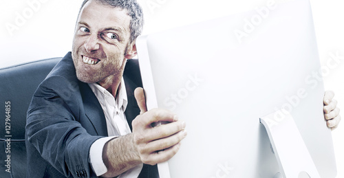 Fotografija enraged businessman with bulging eyes and teeth holding computer