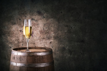 Glass of white wine on wooden barrel