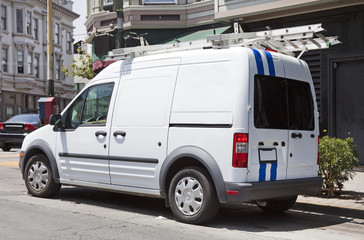 Parked utility truck in urban setting. Side and rear view. Horizontal.