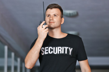 Security man in corridor using portable radio