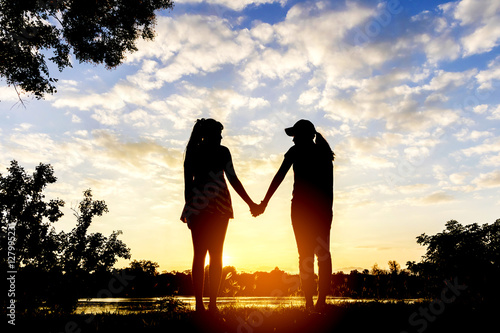 Teenage Sisters Holding Hands Silhouettes At Sunset Buy This Stock