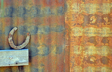 Old Horse Shoe Resting Against Rusty Patterned Corrugated Iron Shed Wall
