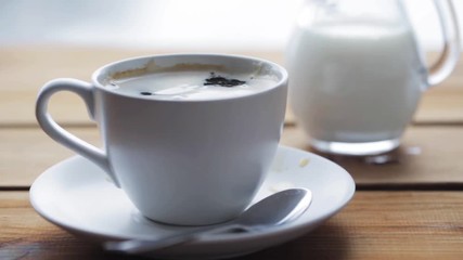 Poster - hand dropping sugar into coffee cup on table