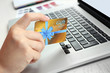 © Africa Studio - Woman with gift card and laptop, closeup. Shopping online. Holiday celebration concept.