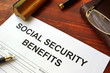 Social security benefits form, book and glasses.