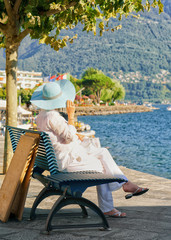 Senior lady sitting on bench of Ascona resort at Switzerland