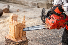 The Sculptor Carves The Wood With The Chainsaw