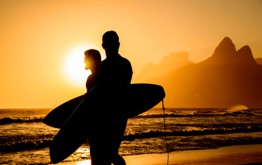 Wall Mural - Golden sunset in Ipanema Beach with Two Brothers, Dois Irmaos, Mountain and two surfers silhouettes, Rio de Janeiro, Brazil