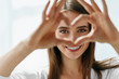 Leinwandbild Motiv Beautiful Happy Woman Showing Love Sign Near Eyes.