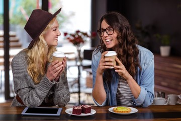 Smiling friends enjoying coffee and pastries