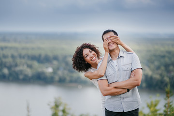 Wall Mural - smiling sexy young woman closing her boyfriend's eyes