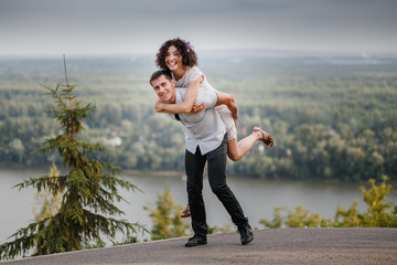 Wall Mural - portrait of attractive caucasian young couple piggybacking outdoors.