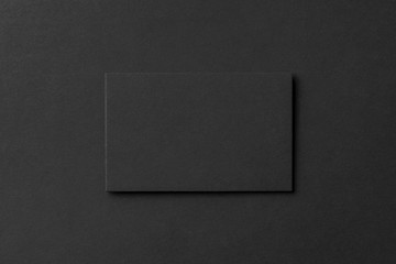 mockup of blank business card at black textured background.