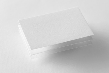 Wall Mural - Mockup of three business cards at white textured background.