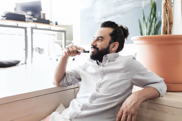 Canvas Print - smiling man with beard and hair bun at office