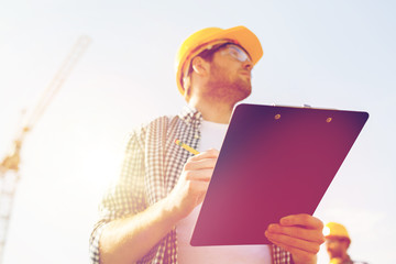 Poster - builder in hardhat with clipboard outdoors