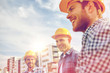 © Syda Productions - group of smiling builders in hardhats outdoors