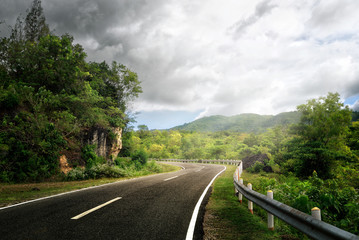 Canvas Print - Empty curved roadway in countryside on sunny light.