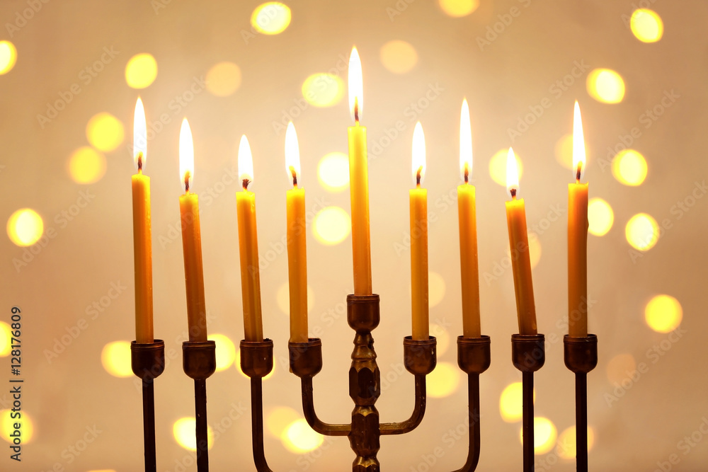 Menorah with candles for Hanukkah against defocused lights, close up