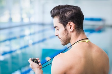 Wall Mural - Handsome man holding stopwatch