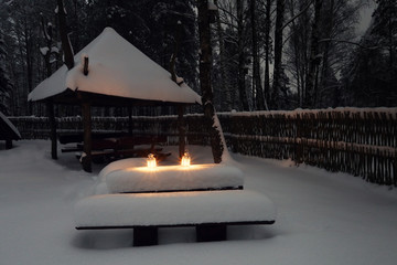 Poster - Snow in village at christmas night. White decorative lights with candles on snow