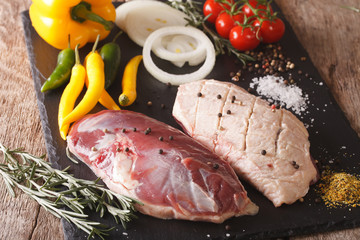 raw fillet of duck with vegetables and spices close-up on the chopping board. horizontal