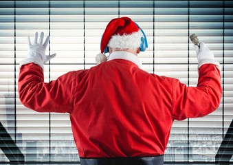 Wall Mural - Santa listening to headphones against window