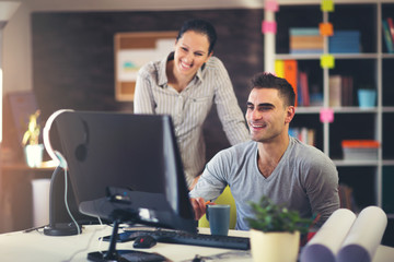 Creative business colleagues using desktop computer in office