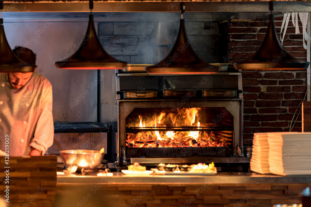 Burning grill in the oven at restaurant kitchen - obrazy, fototapety, plakaty 