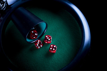 Casino theme. High contrast image of casino roulette, poker game, dice game, poker chips on a gaming table, all on colorful bokeh background. Place for typography and logo.