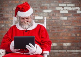 Wall Mural - Santa claus using a digital tablet