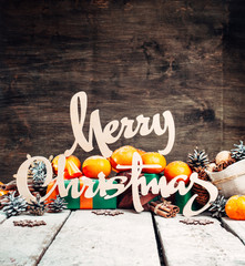 Wall Mural - Christmas home decoration, Wood rustic Xmas background with wooden letters.Dry Oranges,cinnamon sticks,Nuts.Ornaments.Gifts in Boxes.Free space.