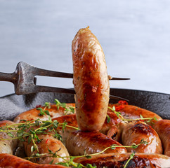 Wall Mural - Home-made Pork Sausages in rustic pan with thyme