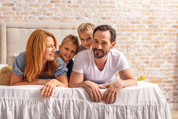 Wall Mural - Parents lying in bedroom with kids