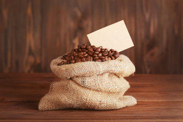 Poster - Purse with roasted coffee beans on wooden background