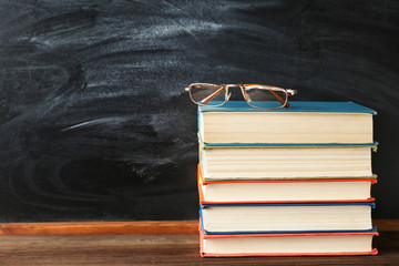 Sticker - Books and glasses on blackboard background