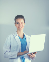 Beautiful woman doctor or nurse holding laptop computer isolated on a white background