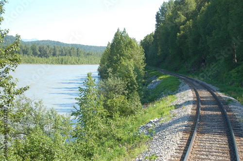 Fotografía Train rolling past lake and mountain