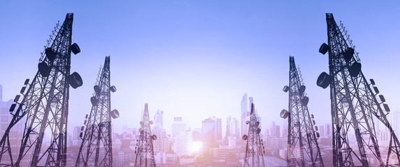 Silhouette, telecommunication towers with TV antennas and satellite dish in sunset, with double exposure city in sunrise background