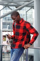 Canvas Print - Young man standing at station with mobile phone