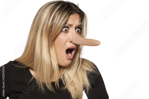 shocked young woman looking in her elongated nose. concept of lying